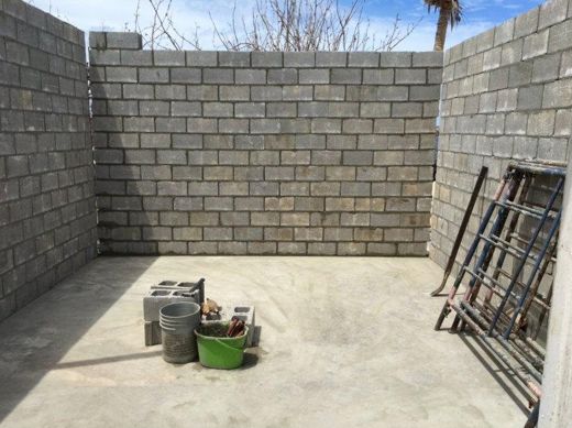 Rebuilding begins: new block walls going up on the old slab.