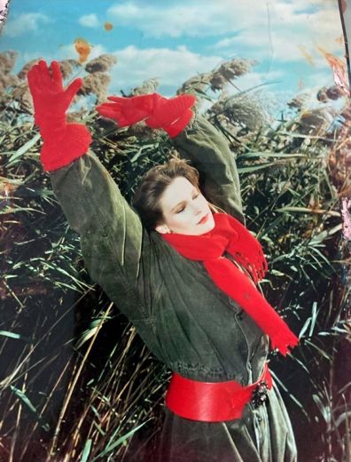 Red gloves and a red scarf, in the reeds by the water.