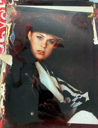 A black beret and a high collar. The surface of the print has lifted.