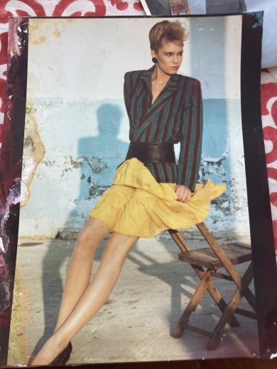 A Model Workshop print: striped blazer and yellow skirt, on a canvas chair against a white wall.